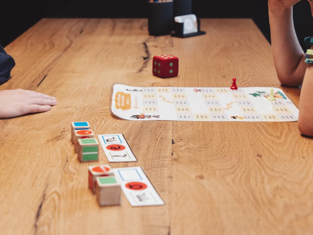 Rekenspel met dobbelsteen en blokjes op de praktijktafel