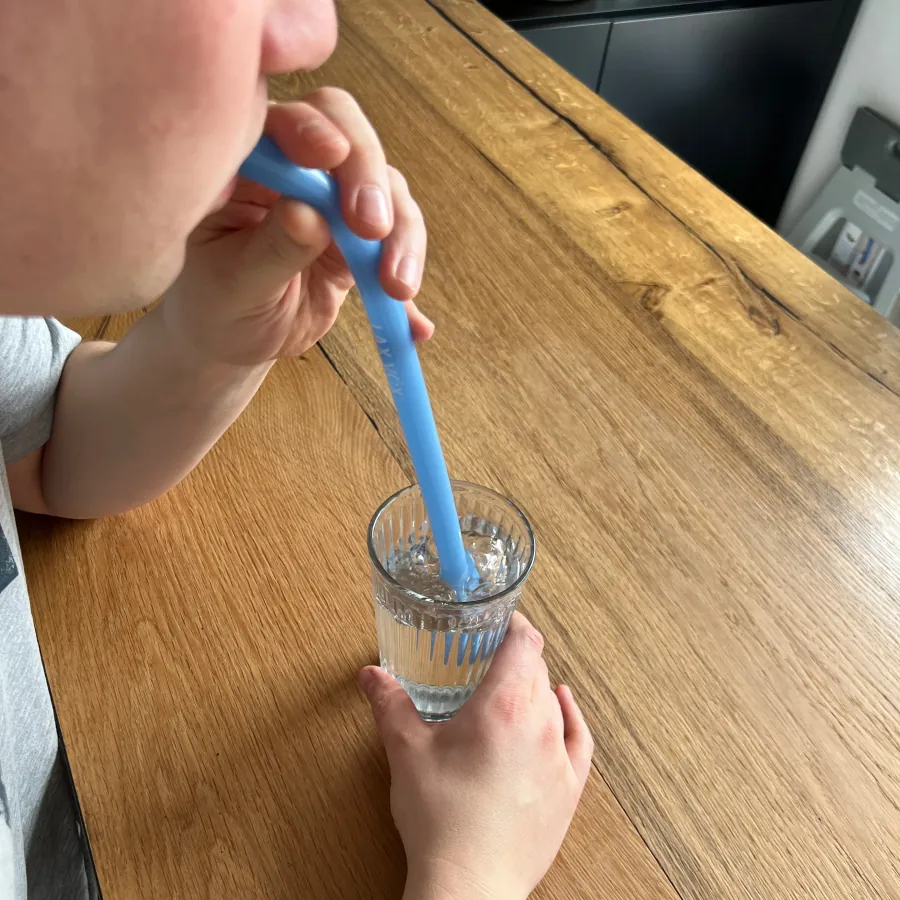 Stemoefening met een siliconen buisje in een glas water