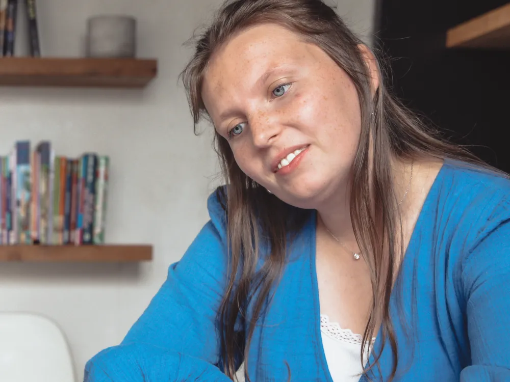 Julie neemt oefenmateriaal in een map door aan de praktijktafel